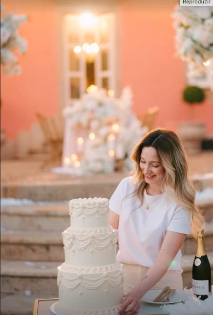 Maria junto a um bolo de casamento